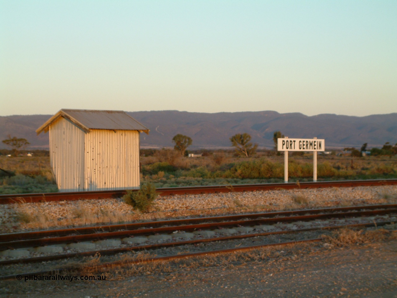 030403 180231
Port Germein, twilight shot of station name board and waiting shelter, Flinders Ranges form the backdrop.
