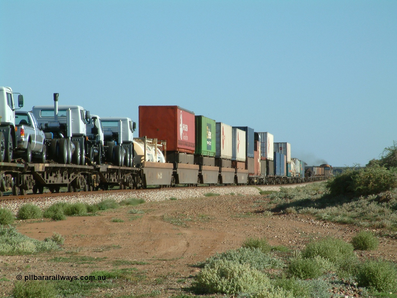 030404 082858
Port Germein, Perth bound steel and intermodal hurries through on the main behind National Rail's NR class units, showing one and a half stacking and new vehicles on flat waggons. 4th April 2003.
