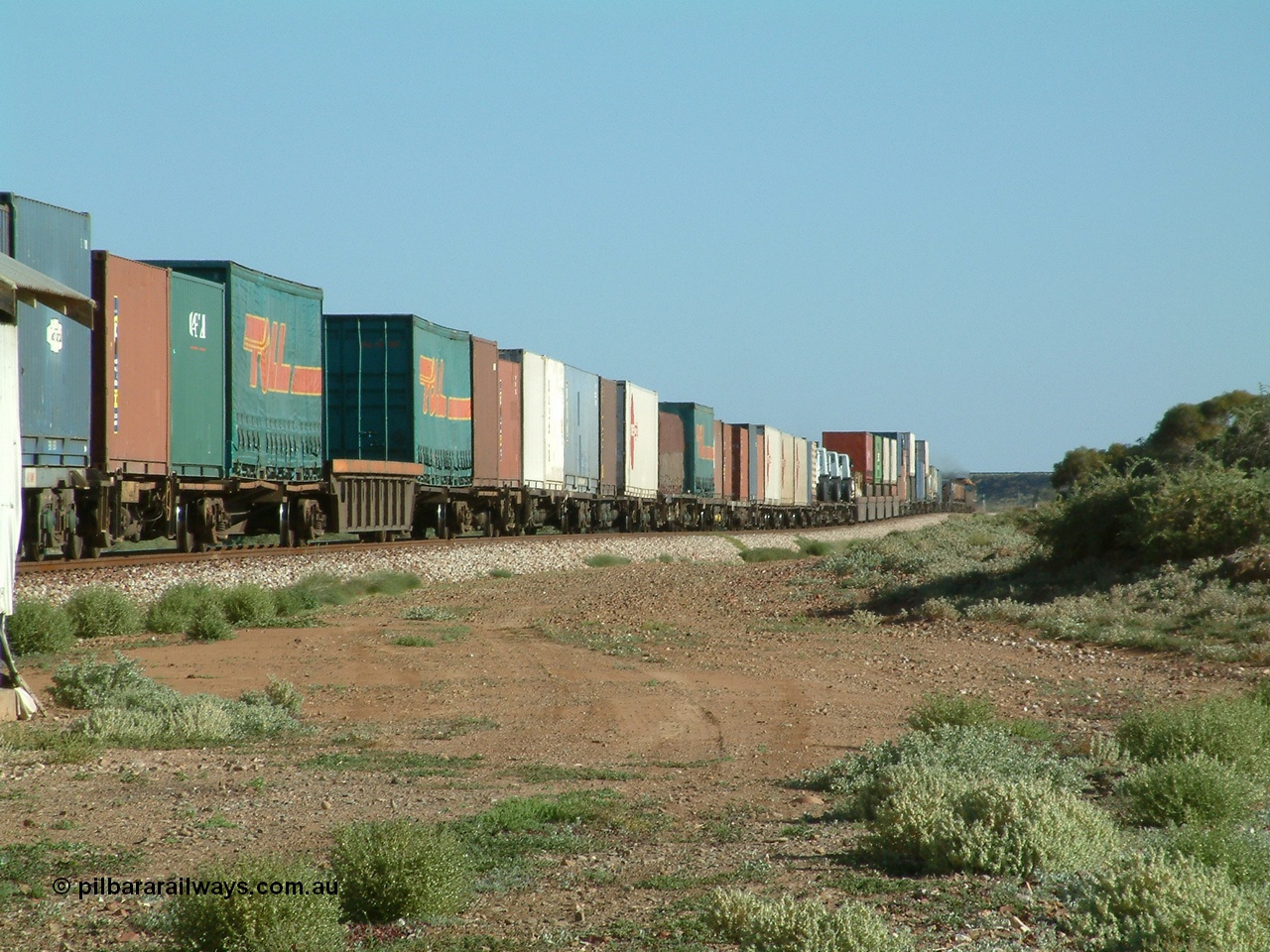 030404 082917
Port Germein, Perth bound steel and intermodal hurries through on the main behind National Rail's NR class units, showing one and a half stacking and new vehicles on flat waggons. 4th April 2003.

