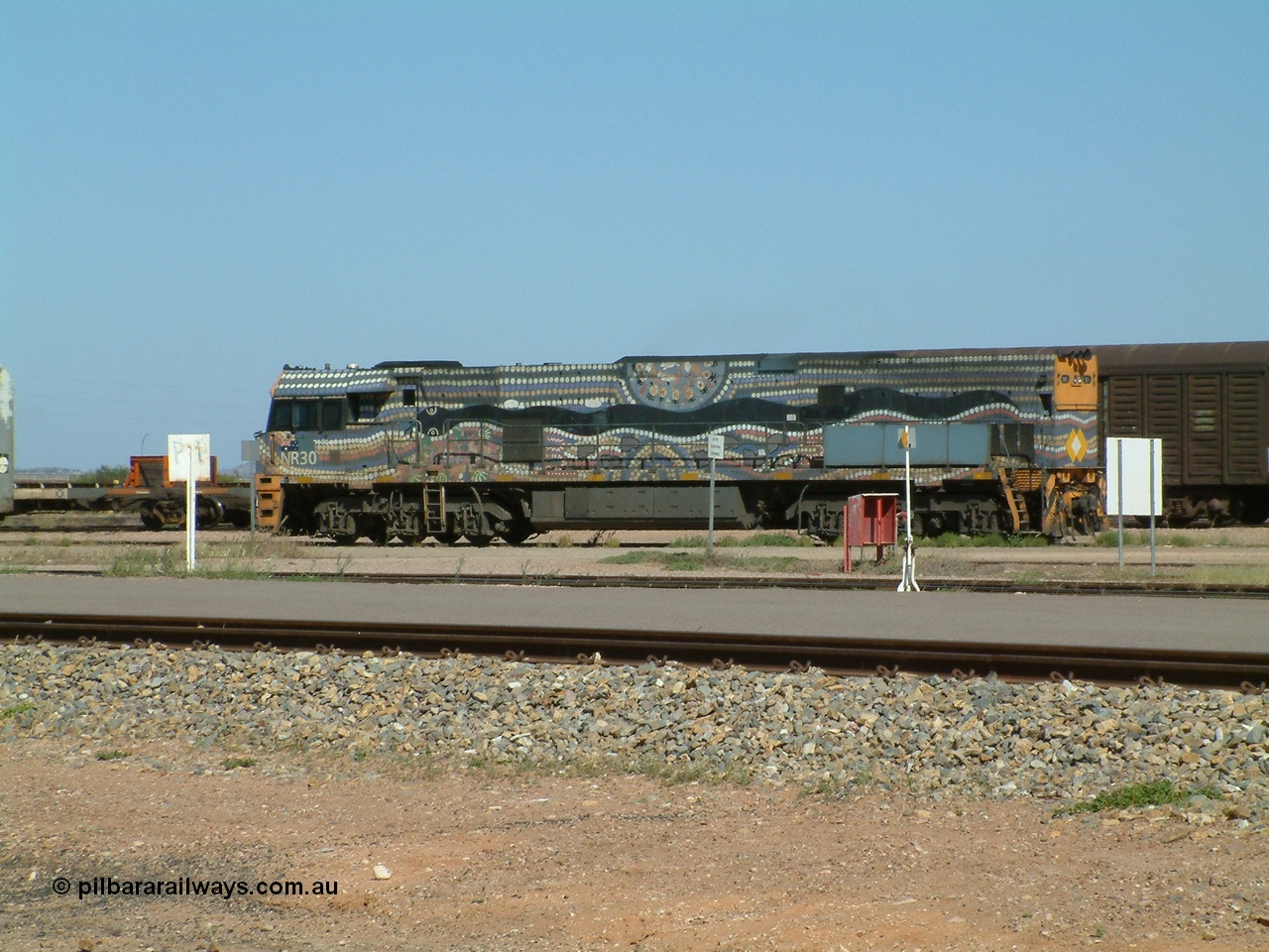 030404 103000
Port Augusta, Goninan built GE model Cv40-9i NR class unit NR 30 serial 7250-05 / 97-232 was painted in a Bessie Liddle of Alice Springs designed aboriginal livery titled 'Warmi' or the snake, John Moriarty of Balarinji Design did the artwork.
Keywords: NR-class;NR30;7250-05/97-232;Goninan;GE;Cv40-9i;