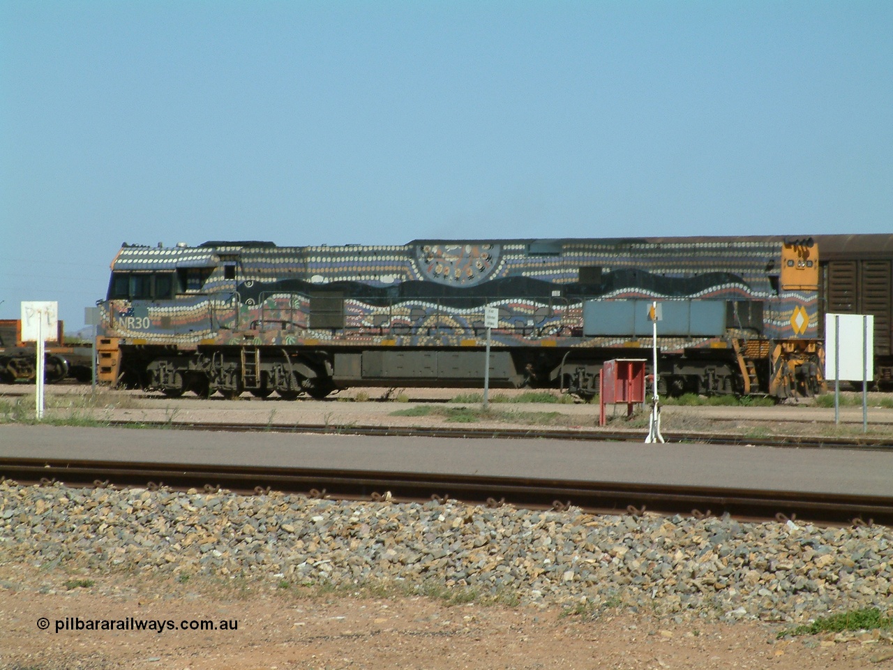 030404 103013
Port Augusta, Goninan built GE model Cv40-9i NR class unit NR 30 serial 7250-05 / 97-232 was painted in a Bessie Liddle of Alice Springs designed aboriginal livery titled 'Warmi' or the snake, John Moriarty of Balarinji Design did the artwork.
Keywords: NR-class;NR30;7250-05/97-232;Goninan;GE;Cv40-9i;