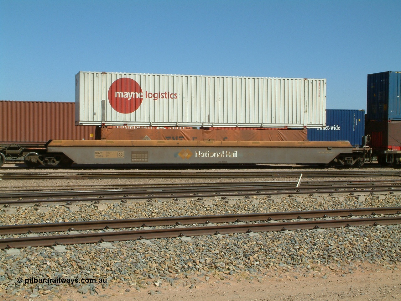 030404 104443
Port Augusta, Spencer Junction yard, RQZY type five unit bar coupled well container waggon RQZY 7050 built as one of a batch of thirty two by Goninan NSW for National Rail, with a Mayne Logistics 48' box DRC 180 on top of a TNT tarped 40' half height unit. 4th April, 2003.
Keywords: RQZY-type;RQZY7050;1995-96/32-16;Goninan-NSW;