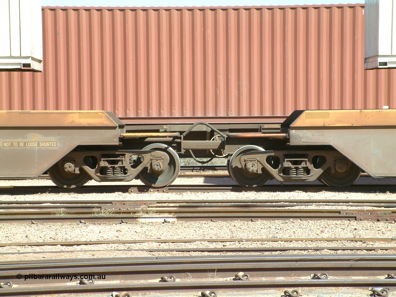030404 104454
Port Augusta, Spencer Junction yard, RQZY type five unit bar coupled well container waggon RQZY 7050 built as one of a batch of thirty two by Goninan NSW for National Rail, detail of the bar coupling arrangement. 4th April, 2003.
Keywords: RQZY-type;RQZY7050;1995-96/32-16;Goninan-NSW;