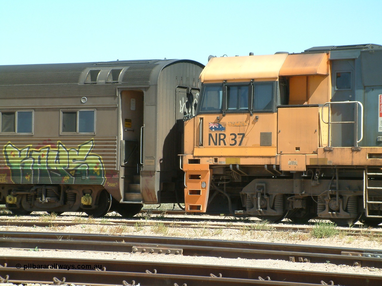 030404 125253
Port Augusta Spencer Junction yard, a Perth bound intermodal awaits departure time on 13 Road behind National Rail NR class unit built by Goninan as GE Cv40-9i models, NR 37 serial 7250-06 / 97-239. 4th April 2003.
Keywords: NR-class;NR37;Goninan;GE;Cv40-9i;7250-06/97-239;