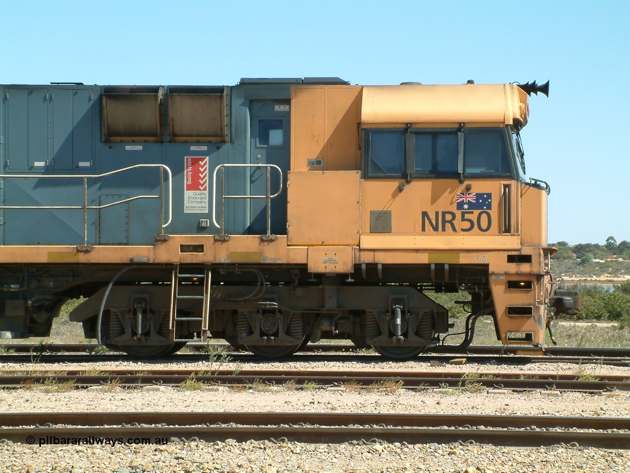 030404 125337
Port Augusta Spencer Junction yard, a Perth bound intermodal awaits departure time on 13 Road behind National Rail NR class units built by Goninan as GE Cv40-9i models, NR 50 serial 7250-08 / 97-252. 4th April 2003.
Keywords: NR-class;NR50;Goninan;GE;Cv40-9i;7250-08/97-252;