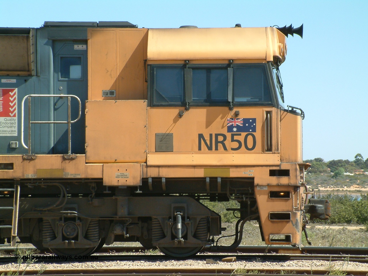 030404 125349
Port Augusta Spencer Junction yard, a Perth bound intermodal awaits departure time on 13 Road behind National Rail NR class units built by Goninan as GE Cv40-9i models, NR 50 serial 7250-08 / 97-252. 4th April 2003.
Keywords: NR-class;NR50;7250-08/97-252;Goninan;GE;Cv40-9i;