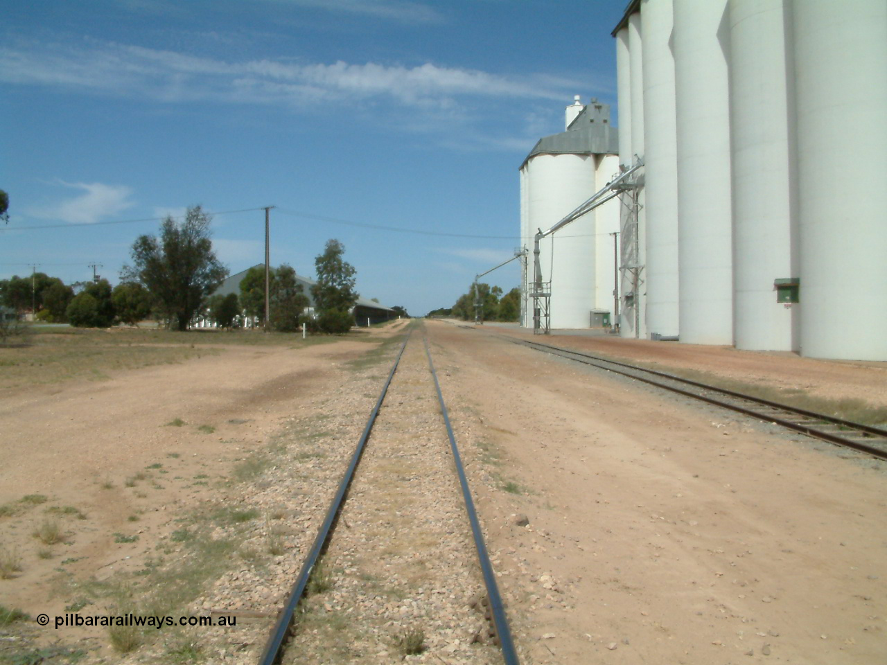 030405 133308
Wudinna, yard view looking along the mainline south with grain shed on the left and silo complexes and loading spouts on the right, old station site on the left, 5th April 2003.
