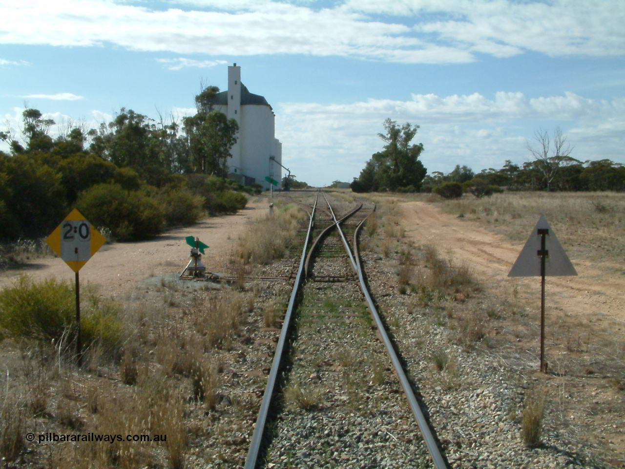030405 150340
Warramboo, yard overview looking north with siding point levers and indicators, 20 km/h speed restriction signs, concrete SACBH silo complex on the left, 5th April 2003.
