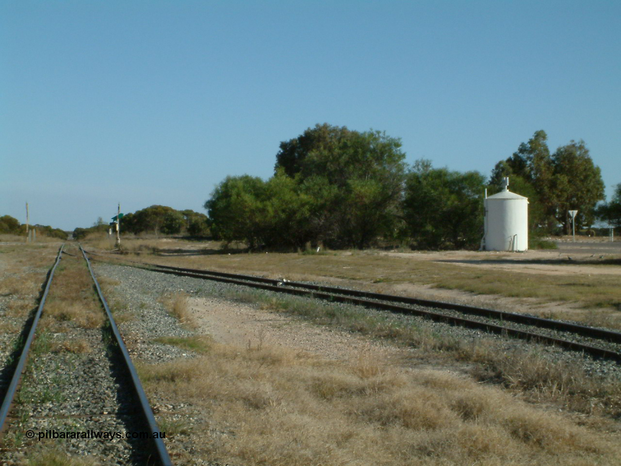 030405 155852
Lock, yard view looking south, grain silo siding point lever and indicator with derail, circular concrete toilet for grain complex, grade crossing for Birdseye Hwy visible in the distance. 5th April 2003.
