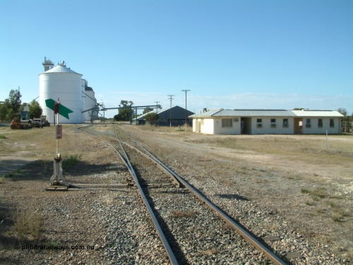 030405 160328
Lock, station yard overview, located at the 148.5 km, originally opened in May 1913 and called Terre after a local property, renamed to Lock in December 1921. Looking north along the mainline, points, lever and indicator for grain siding, Ascom style silo complex with concrete behind them, horizontal grain shed on the right with former crew barracks in front of that. April 5, 2003.
