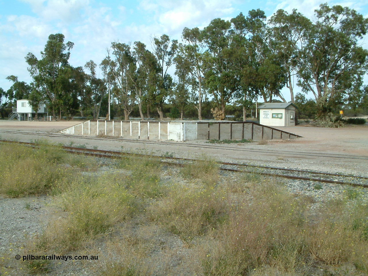 030406 084446
Tooligie, yard view looking across mainline to siding and loading ramp, weighbridge scale room in the right background. 6th April 2003.

