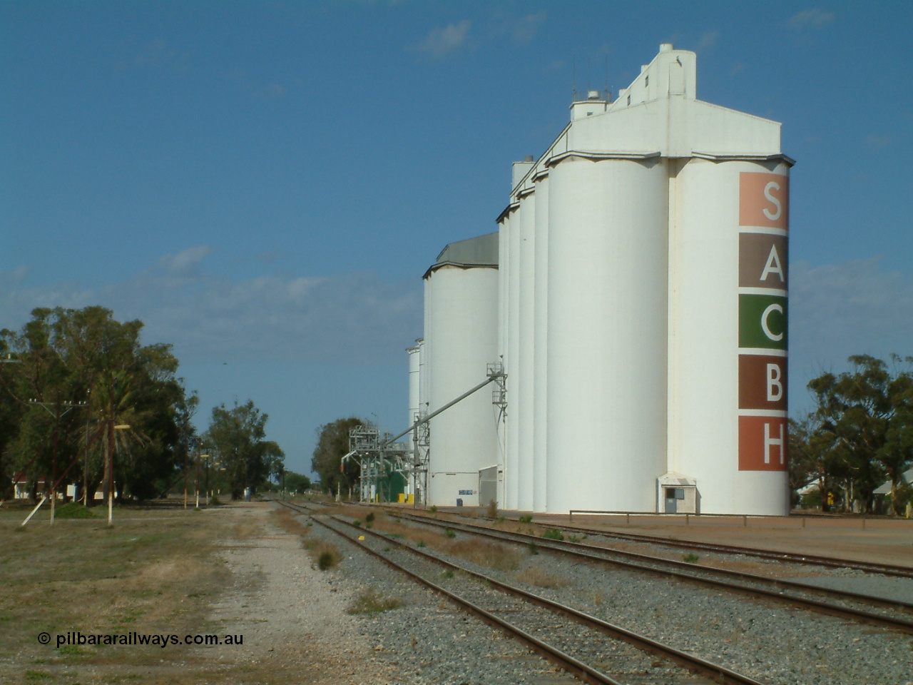030406 095408
Cummins, view of the three grain storage silo complexes, looking south along the old alignment for the fourth siding, and barracks at the left of frame. 6th April 2003.
