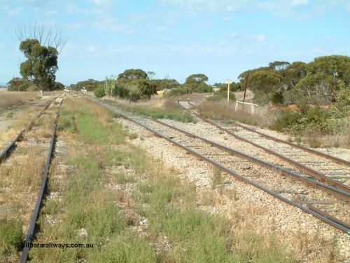 030406 092756
Yeelanna, yard view looking south, shows mainline and grain siding running south and branch line to Kapinnie and former Mount Hope branch curving away to the right across a culvert and past a cast Yard Limit sign. 6th April 2003.
