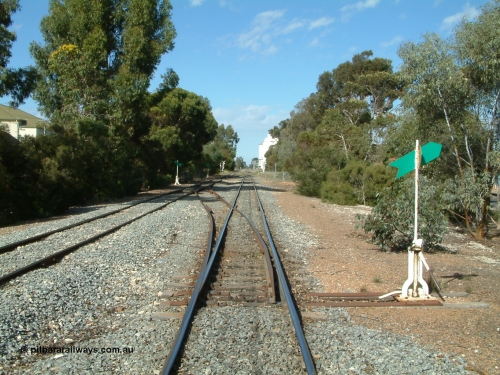 030406 094714
Cummins, yard overview looking south down the mainline from Thevenard with the line from Buckleboo coming in on the left, points, levers and indicators for the crossovers being visible with crib crossing and concrete silos in the distance. 6th April 2003.
