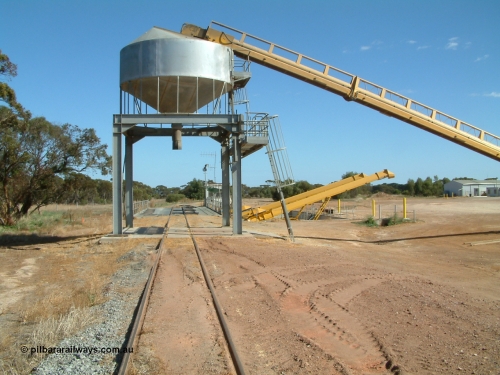 030406 100902
Cummins, view of the grain bunker rail unloading facility with dual DOH 'Drive Over Hopper' and stackers for loading road vehicles and with the original overhead outflow bin and feed conveyor for loading rail waggons. 6th April 2003.
