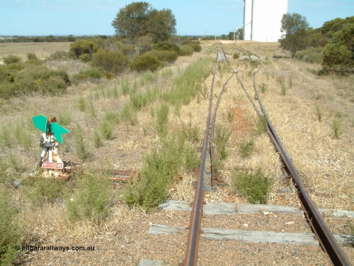 030406 141824
Kapinnie, station yard overview looking east towards Yeelanna, from the terminus end of line with dwarf point lever and indicator, concrete silo complexes with outflow spouts, scotch block visible on siding. April 6, 2003.
