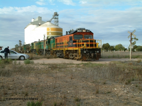 030409 080651
Warramboo, empty grain prepares to get underway following a crew change. Rebuild unit DA 7 in Australian Southern orange and black livery leads a pair of AE Goodwin built ALCo model DL531 830 class units 872 and 871, the relieved crew get in their car with the SACBH concrete silo complex behind.
Keywords: DA-class;DA7;83713;Port-Augusta-WS;ALCo;DL531G/1;48-class;4813;rebuild;