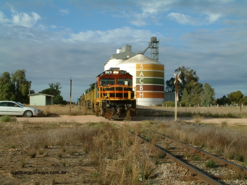 030409 080811
Warramboo, empty grain prepares to get underway following a crew change. Rebuild unit DA 7 in Australian Southern orange and black livery leads a pair of AE Goodwin built ALCo model DL531 830 class units 872 and 871, the relieved crew in the car with the long disused station building on the left and the SACBH concrete silo complex on the right rounding out the scene.
Keywords: DA-class;DA7;83713;Port-Augusta-WS;ALCo;DL531G/1;48-class;4813;rebuild;