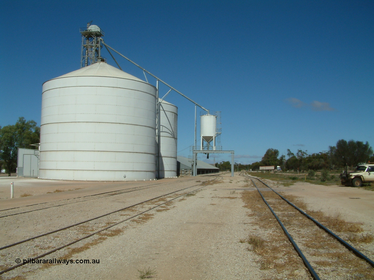 030411 110609
Kimba, view looking south of the Ascom Jumbo style silo complex, truck discharge on the left, outloading spout and silo over rail, horizontal bunker behind.
