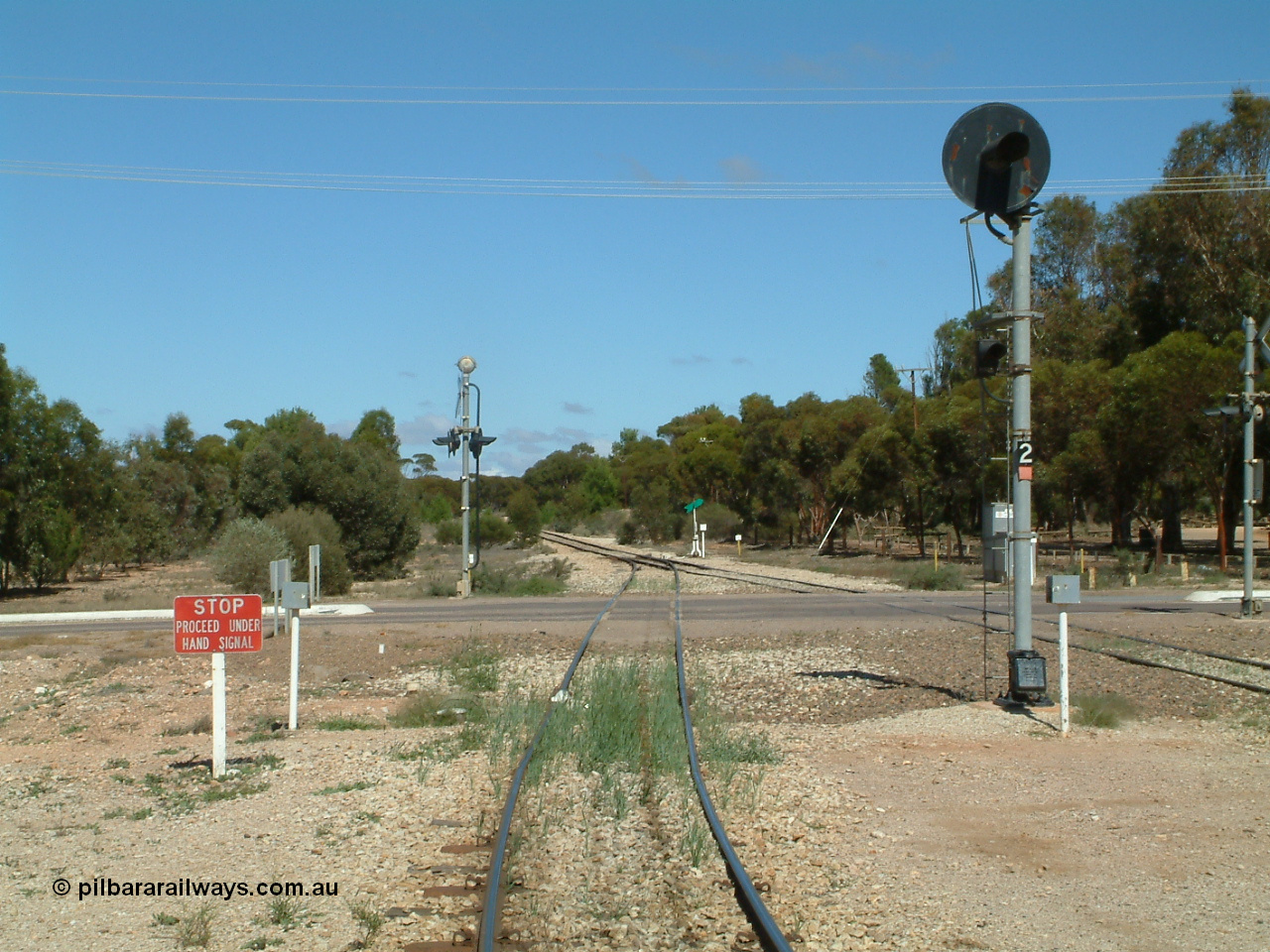 030411 110811
Kimba, looking south across the Eyre Highway grade crossing, the grain road has to use hand signals, the mainline has a coloured light, one of only three such signals on the Eyre Peninsula system, the others being at Kyancutta and Port Lincoln.
