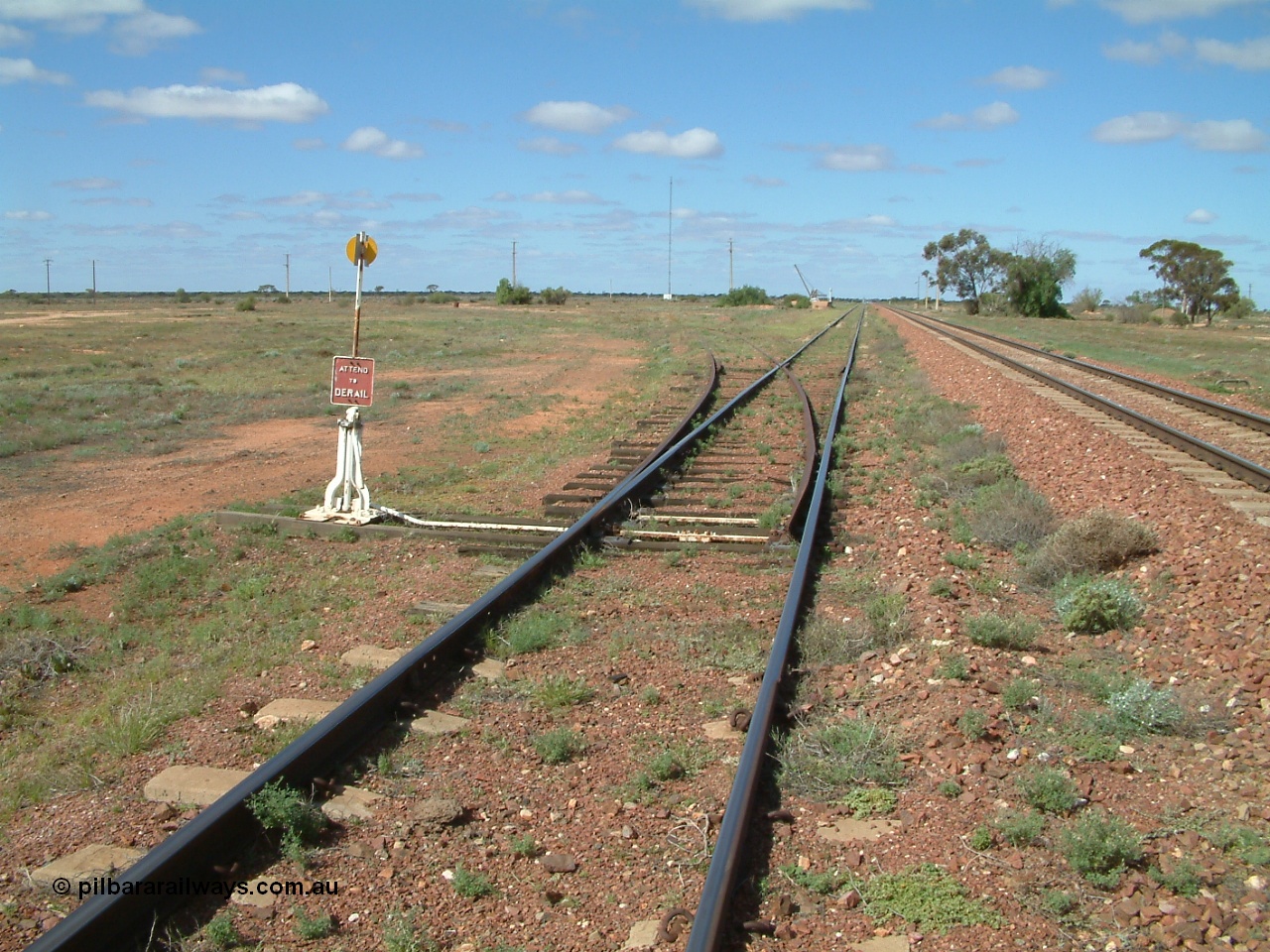 030415 140420
Kingoonya, located at the 426.5 km on the Trans Australian Railway, looking east along the loop siding with the mainline on the right and points and sidings off to the left, loading ramp and crane in distance, town located to the right. [url=https://goo.gl/maps/rY8C9mU9iF4tBmjF7]GeoData location[/url].
