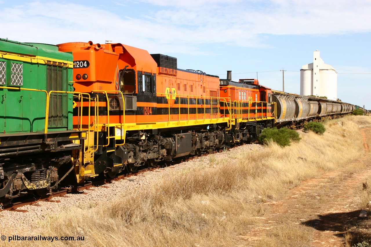 060109 2116
Kyancutta, ARG's Clyde Engineering built EMD G12C 1200 class unit 1204 serial 65-428 was originally built for the WAGR as their A class unit A 1514. Due to air-conditioning trouble it is in the shafts as they shunt across Museum Terrace to place empty grain waggons on the silo loop. 9th January 2006.
Keywords: 1200-class;1204;Clyde-Engineering-Granville-NSW;EMD;G12C;65-428;A-class;A1514;