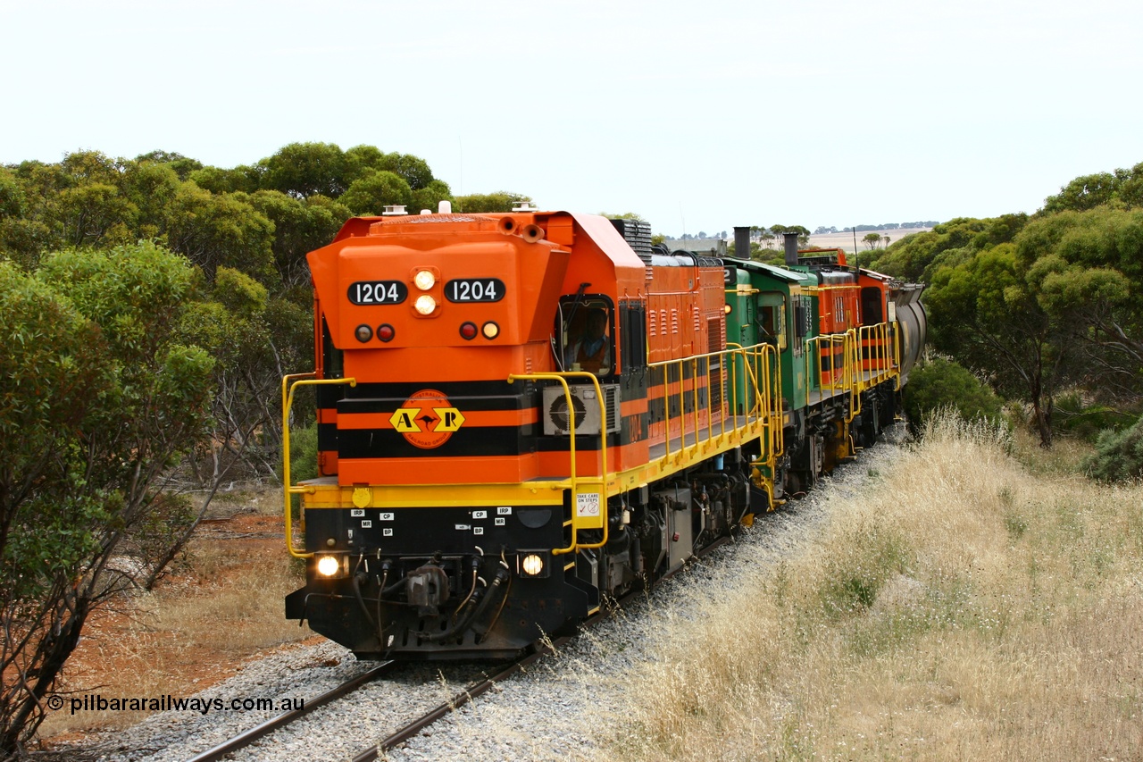 060110 2214
On the curve near the 85 km between Yeelanna and Karkoo, ARG 1200 class unit 1204, a Clyde Engineering EMD model G12C serial 65-428, originally built for the WAGR as the final unit of fourteen A class locomotives in 1965 and sent to the Eyre Peninsula in July 2004 leads an empty grain train. [url=https://goo.gl/maps/7kwfXBE6nS12]Approx. location of image[/url].
Keywords: 1200-class;1204;Clyde-Engineering-Granville-NSW;EMD;G12C;65-428;A-class;A1514;