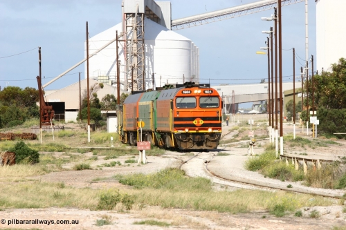 060113 2462
Thevenard, narrow gauge loco 1604 with a fresh crew depart the yard with empty train 6DD3, 1604 leads a triple consist of Clyde Engineering built EMD JL22C model 1600 / NJ class combination of 1604 serial 71-731 and originally NJ 4, NJ 3 serial 71-730 and 1601 serial 71-728 the original class leader NJ 1, all three units started on the Central Australia Railway in 1971 and were transferred to the Eyre Peninsula in 1981. 1604 and 1601 both renumbered in 2004. A roll-by is also being conducted by an outgoing crew member. 13th January 2006.
Keywords: 1600-class;1604;Clyde-Engineering-Granville-NSW;EMD;JL22C;71-731;NJ-class;NJ4;