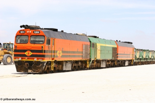 060113 2550
Kevin, standing on the mainline to Thevenard, and the train now identified as 6DD4 has commenced loading of gypsum but the 988 Cat front end loaders which takes about one and half hours to load. As the train reversed on the triangle the consist is the same heading back loaded with 1604 leading NJ 3 and 1601. 13th January 2006.

