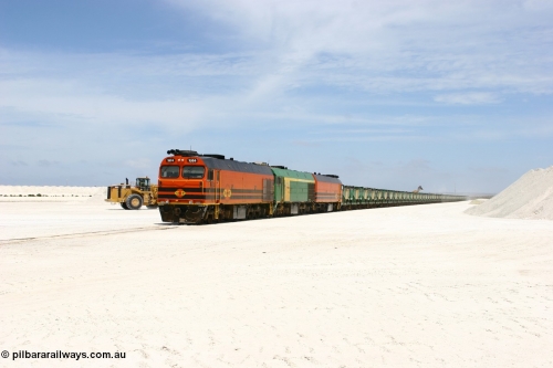 060113 2554
Kevin, narrow gauge locos 1604, NJ 3 and 1601 wait while their return working train 6DD4 is loaded on the mainline to Thevenard. The plant is behind the tipping loader and Kevin back around to the right behind the gypsum pile. 13th January 2006.
