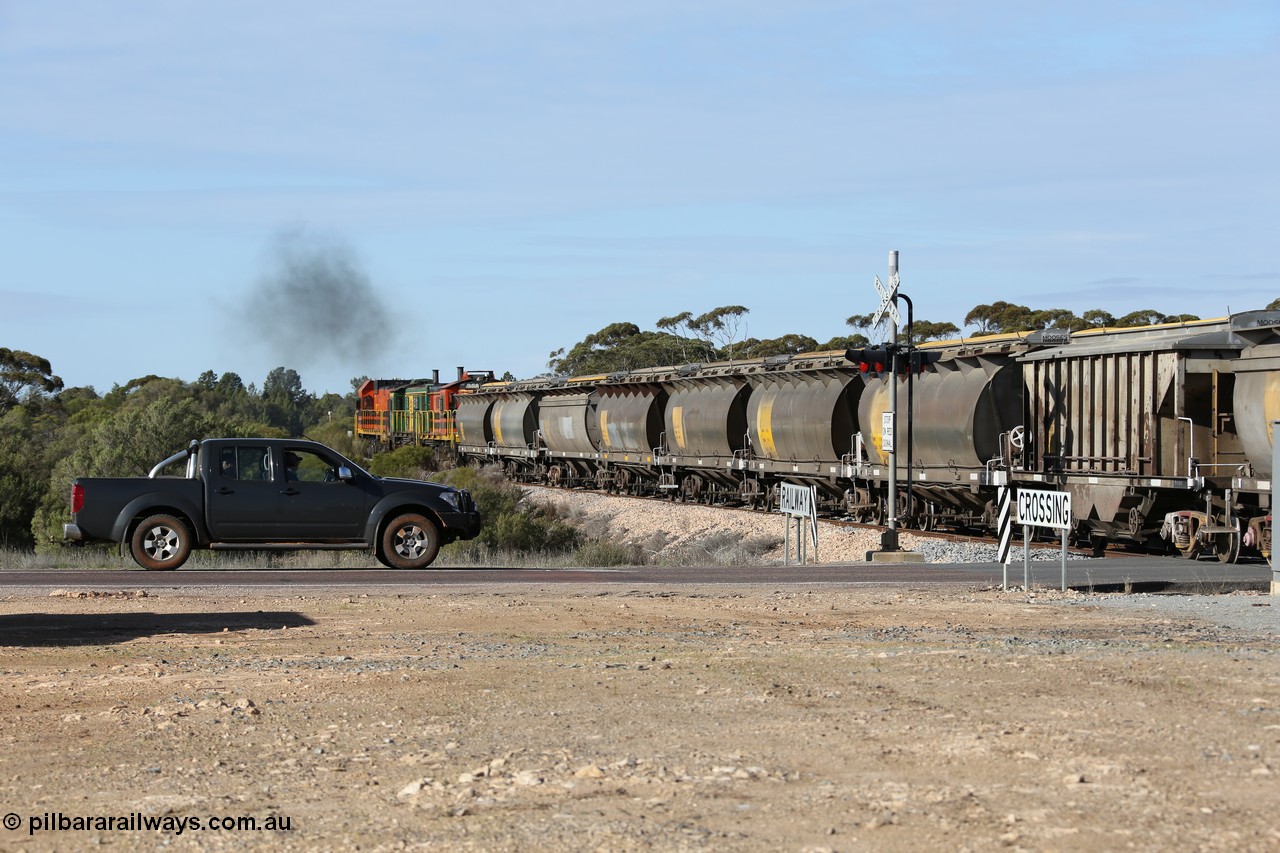 130704 0409
Kyancutta, south bound loaded grain train has stopped here to collect a loaded rack of grain waggons, seen here backing up to re-join the rest of the train on the mainline as it crosses the Eyre Highway grade crossing, behind EMD 1204 and twin ALCo 830 units 873 and 851. 4th July 2013.
