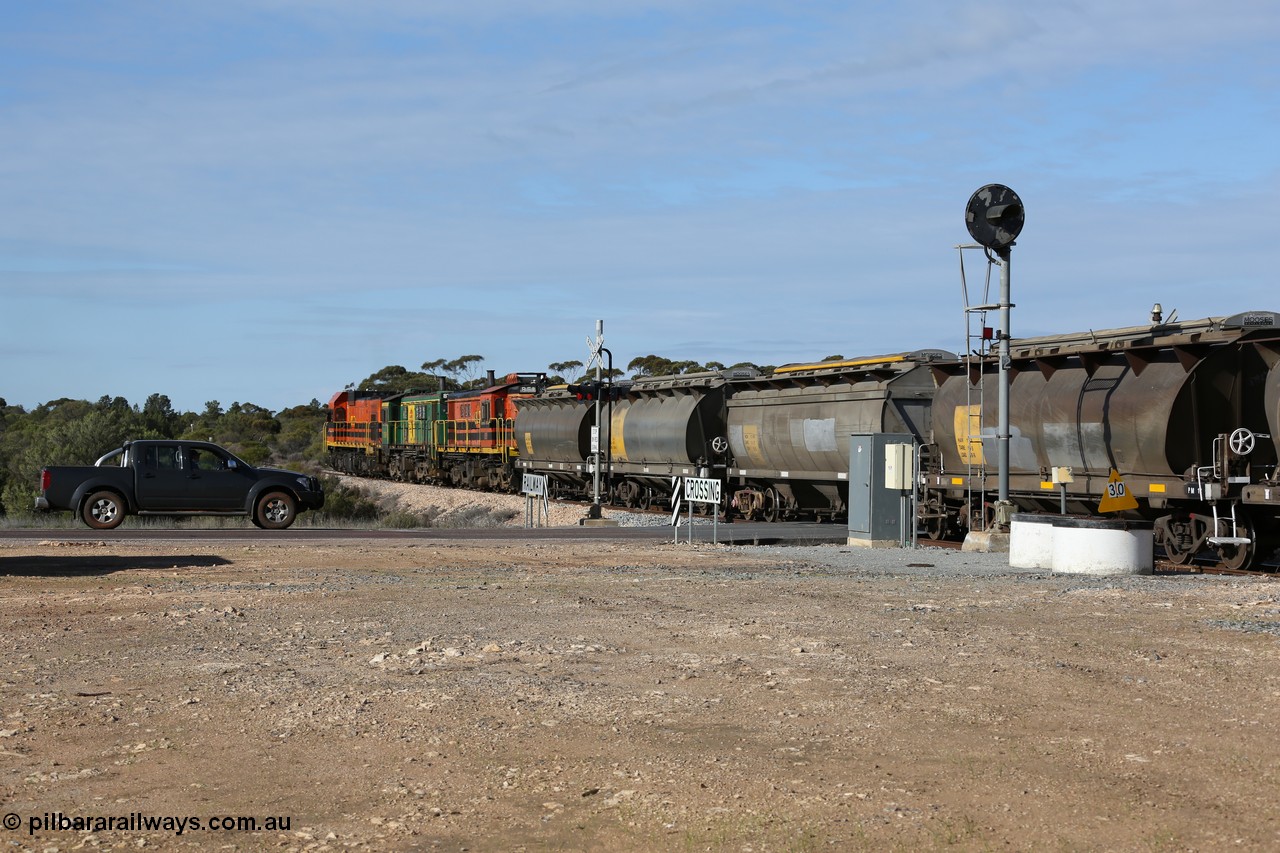 130704 0412
Kyancutta, south bound loaded grain train has stopped here to collect a loaded rack of grain waggons, seen here backing up to re-join the rest of the train on the mainline as it crosses the Eyre Highway grade crossing and one of only three electric signals on the network, behind EMD 1204 and twin ALCo 830 units 873 and 851. 4th July 2013.
