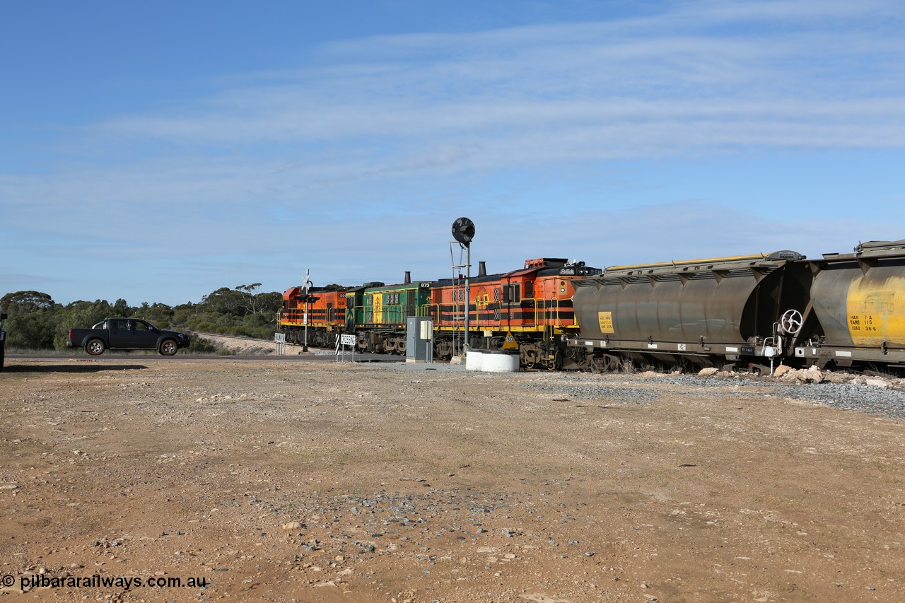 130704 0414
Kyancutta, south bound loaded grain train has stopped here to collect a loaded rack of grain waggons, seen here backing up to re-join the rest of the train on the mainline as it crosses the Eyre Highway grade crossing and one of only three electric signals on the network, behind EMD 1204 and twin ALCo 830 units 873 and 851. 4th July 2013.
