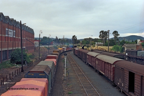 100-04
Albury yard view, Sydney bound goods, trailing shot, looking north, from Wilson Street footbridge, old Dalgety's building on the left, signal post AY61, louvre vans and motorail waggons on the right. [url=https://goo.gl/maps/nngpTA37VQekQpCt7]Geodata[/url].
