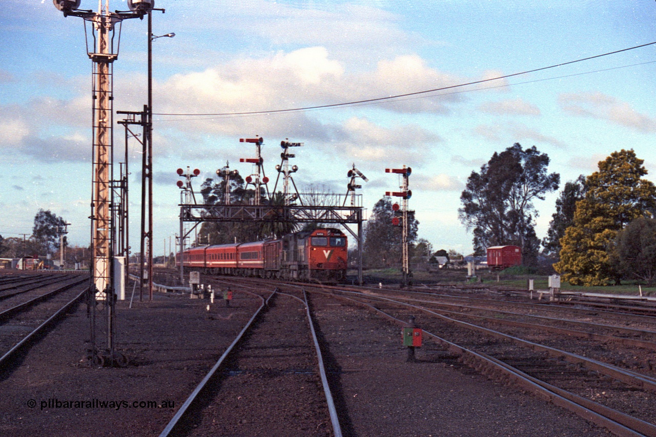103-32
Benalla station yard overview looking north, broad gauge V/Line N class loco N 456 'City of Colac' with serial 85-1224 a Clyde Engineering Somerton Victoria built EMD model JT22HC-2 and N set with up Albury pass under the intact semaphore signal gantry, signal post 20 in front of camera, opposite B box, yard still interlocked.
Keywords: N-class;N456;Clyde-Engineering-Somerton-Victoria;EMD;JT22HC-2;85-1224;