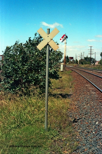 105-24
Wallan, level crossing indicator on up mainline, semaphore signal post 16 with sighting disc behind arm pulled off for up train, twin disc signal post 15 has been stripped, water tank in background, looking south.
