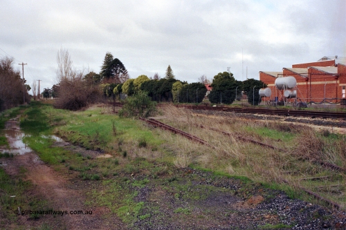 107-05
Kyabram track view, rails for Kyabram Fruit Packers siding, Kyabram Co-op Fruit Preserving Company on the right, looking towards Kyabram.
