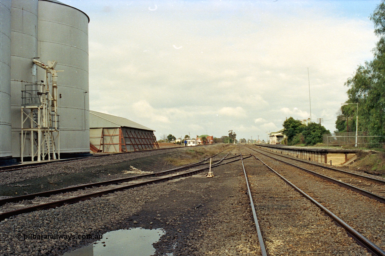 108-13
Murchison East looking towards Melbourne, yard and station overview, gravity track on the left, station platform on the right, Murphy silo and horizontal grain bunker at left.

