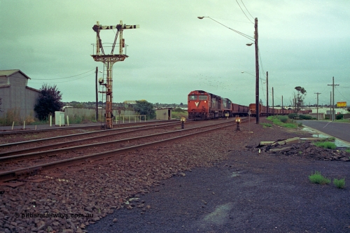 111-01
North Geelong grain arrivals yard, V/Line broad gauge locos N class N 461 'City of Ararat' Clyde Engineering EMD model JT22HC-2 serial 86-1190 and X class X 47 Clyde Engineering EMD model G26C serial 75-794 with a loaded grain rake, semaphore signal post 13 and ground dwarf disc signal 12 and 14 with another loaded grain rake.
Keywords: N-class;N461;Clyde-Engineering-Somerton-Victoria;EMD;JT22HC-2;86-1190;