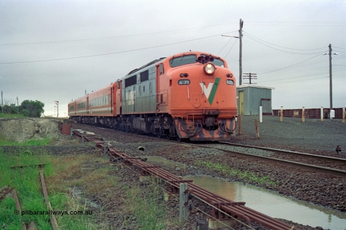111-15
Gheringhap, broad gauge V/Line A class A 71 Clyde Engineering EMD model AAT22C-2R serial 83-1180 rebuilt from B 71 Clyde Engineering EMD model ML2 serial ML2-12 and N set departing with the down Ararat via Nth Geelong passenger train 8105, point rodding, signals wires and the former station platform are visible.
Keywords: A-class;A71;Clyde-Engineering-Rosewater-SA;EMD;AAT22C-2R;83-1180;rebuild;bulldog;
