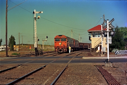 112-17
North Geelong C Box, Separation Street grade crossing, V/Line broad gauge grain train departing North Geelong Yard behind G classes G 534 Clyde Engineering EMD model JT26C-2SS serial 88-1264 and sister unit, signaller handing up electric staff for section to Gheringhap, ground dwarf signal 18 pulled off for departure, semaphores and searchlight signal posts, grade crossing, point rodding and signal box, safeworking.
Keywords: G-class;G534;Clyde-Engineering-Somerton-Victoria;EMD;JT26C-2SS;88-1264;