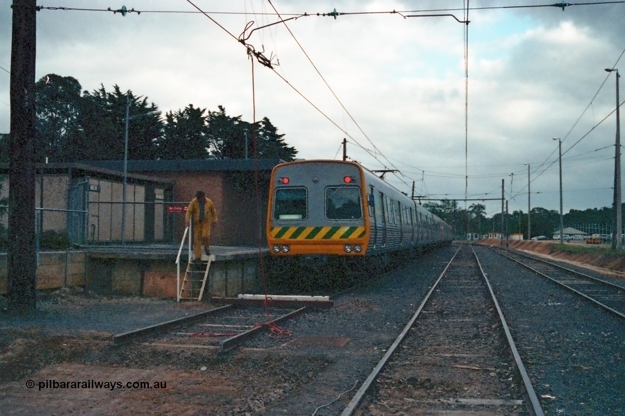 115-07
Hurstbridge, The Met broad gauge six car Comeng electric suburban train, yard view looking south, overhead grounded, stabling sidings, station platform, concrete ablution block.
