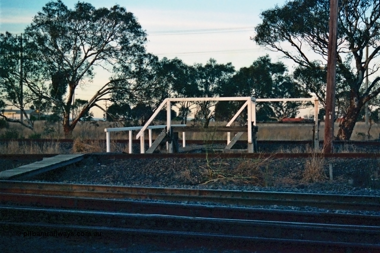 115-12
Somerton, staff exchange platforms for Ford's Siding / Upfield line, far platform for the broad gauge, with the standard gauge using the near platform, lines converge to dual gauge around curve, looking across the North East broad and standard gauge running lines.
