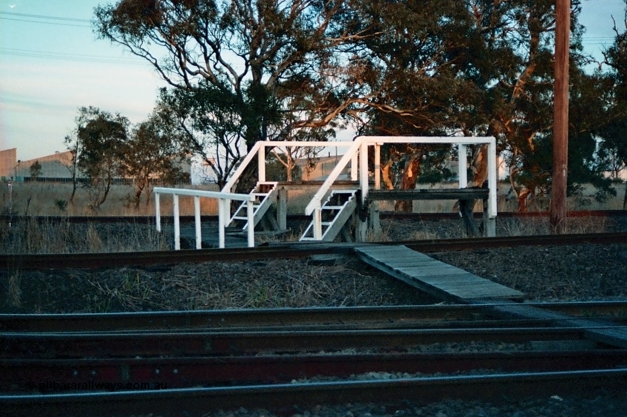 115-17
Somerton, staff exchange platforms for Ford's Siding / Upfield line, far platform for the broad gauge, with the standard gauge using the near platform, lines converge to dual gauge around curve, looking across the North East broad and standard gauge running lines.
