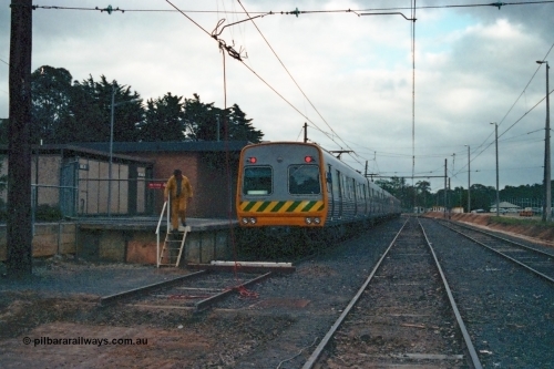 115-07
Hurstbridge, The Met broad gauge six car Comeng electric suburban train, yard view looking south, overhead grounded, stabling sidings, station platform, concrete ablution block.
