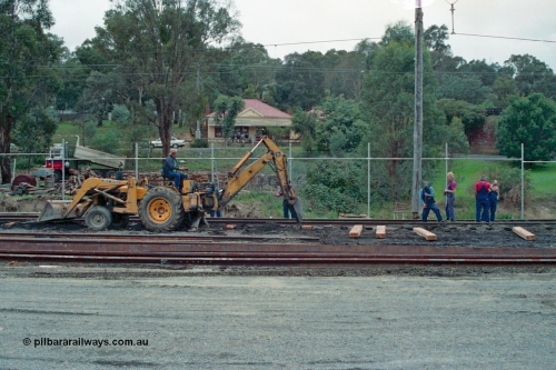 115-08
Hurstbridge, stabling sidings being upgraded, new sleepers being laid, John Deere backhoe and workers, Main Street in the elevated background.
