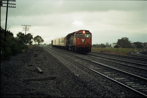 117-02
Somerton, V/Line N class loco N 456 'City of Colac' with serial 85-1224 a Clyde Engineering Somerton Victoria built EMD model JT22HC-2 with up Albury passenger train, standard gauge line on far right, with dual gauge sidings, in driving rain.
Keywords: N-class;N456;Clyde-Engineering-Somerton-Victoria;EMD;JT22HC-2;85-1224;