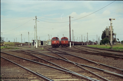 119-03
Nth Geelong yard overview, empty grain trains, V/Line broad gauge N class shunts train back into the Sorting Yard, a G class sits on an empty grain train, looking from Nth Geelong C towards Geelong, grain loop roads and Loop Line at left, semaphore signal post 17 on the right.
Keywords: N-class;N461;Clyde-Engineering-Somerton-Victoria;EMD;JT22HC-2;86-1190;