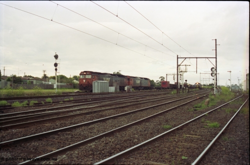 119-16
Sunshine, looking towards Tottenham, broad gauge down goods train 9149 is passed by down standard gauge goods train, V/Line G class locos, looking across all tracks.
