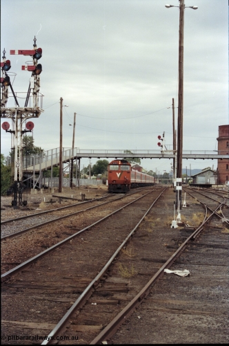 120-26
Wangaratta station yard overview, V/Line broad gauge loco N class N 474 'City of Traralgon' Clyde Engineering EMD model JT22HC-2 serial 87-1203 with down Albury passenger train departing, footbridge, track work, goods shed, point levers, part of semaphore signal post 23.
Keywords: N-class;N474;Clyde-Engineering-Somerton-Victoria;EMD;JT22HC-2;87-1203;